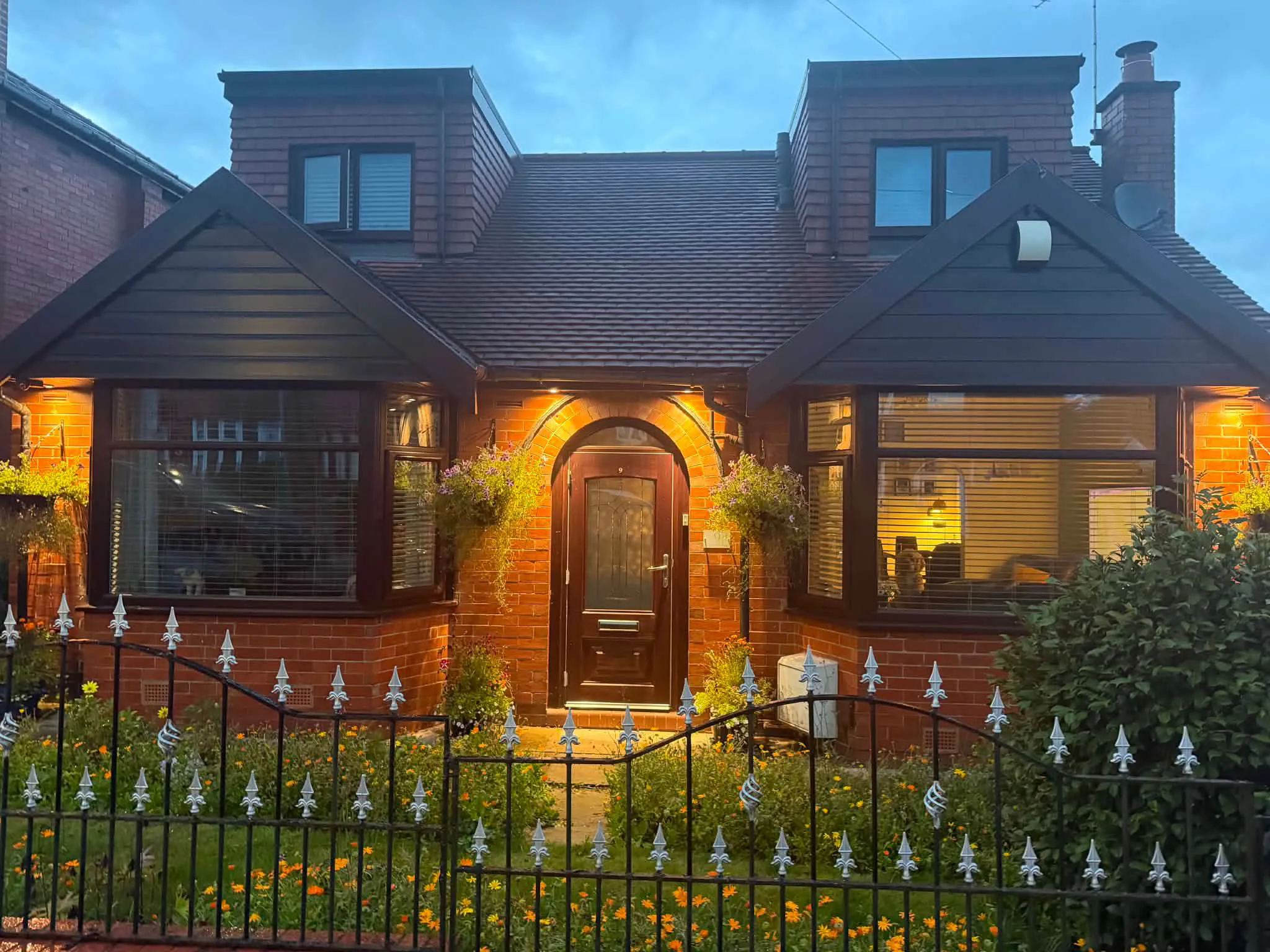 Loft dormer conversion with new upvc windows lit at dusk by LDG Joinery LTD, Bolton